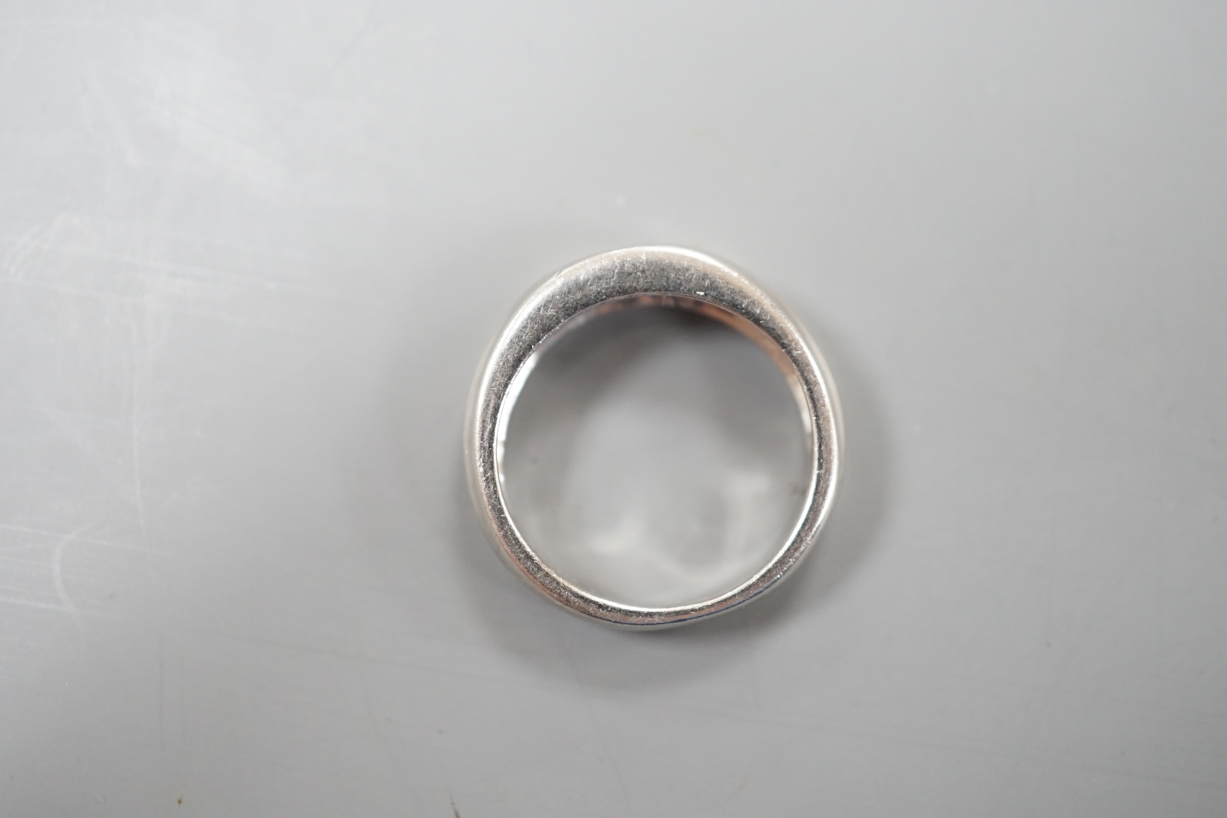 A modern platinum and gypsy set solitaire diamond ring, size K, 6.6 grams.